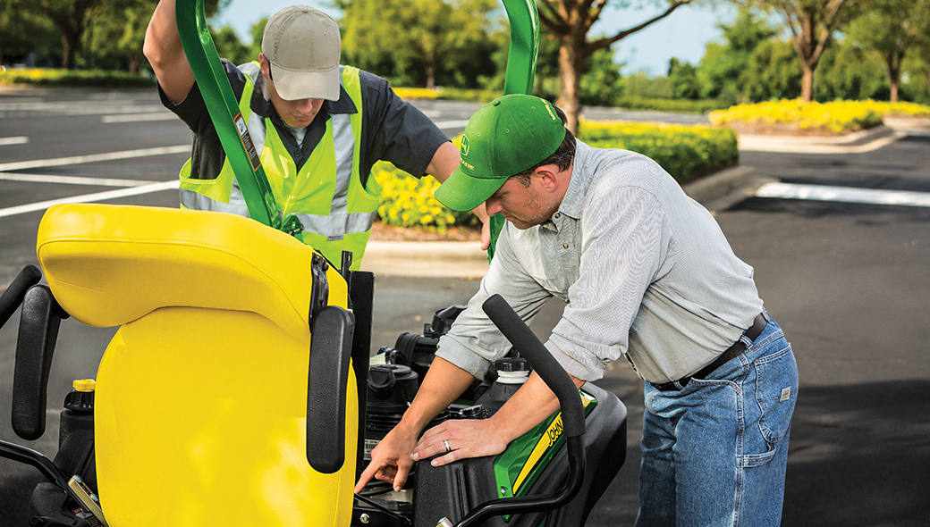 Two men inspecting a Z920M ZTrak Zero Turn Mower in a parking lot